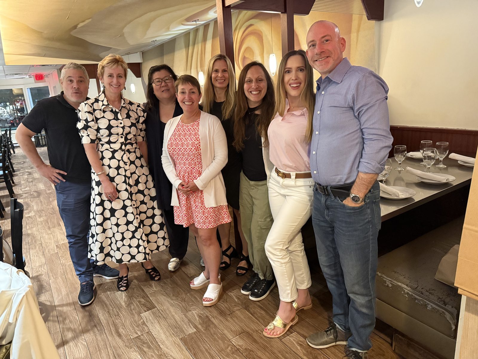 Full group of members posed together at a restaurant