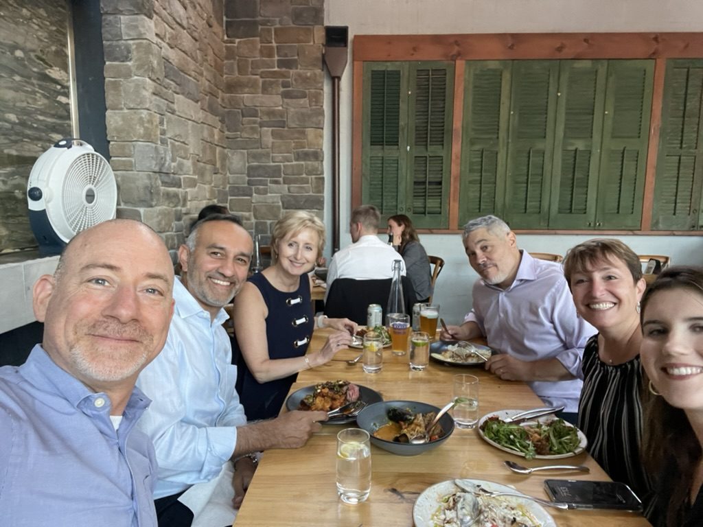 Members at an outdoor lunch on a sunny day