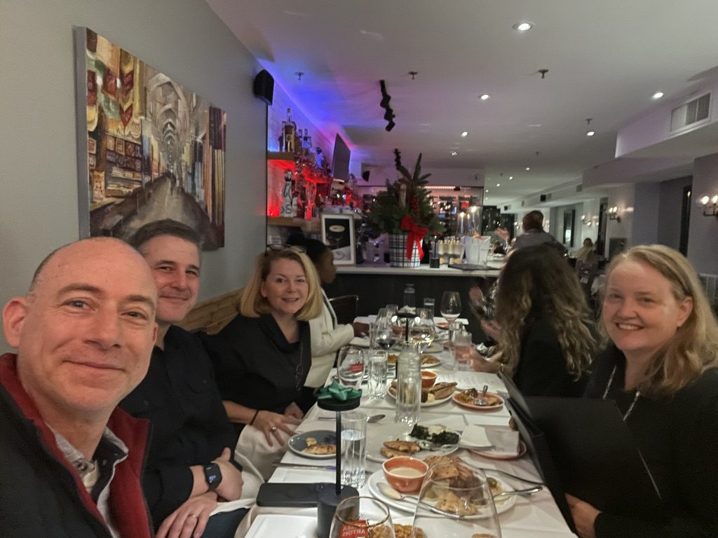 Full group of members at a long formal dinner at Arnaud's