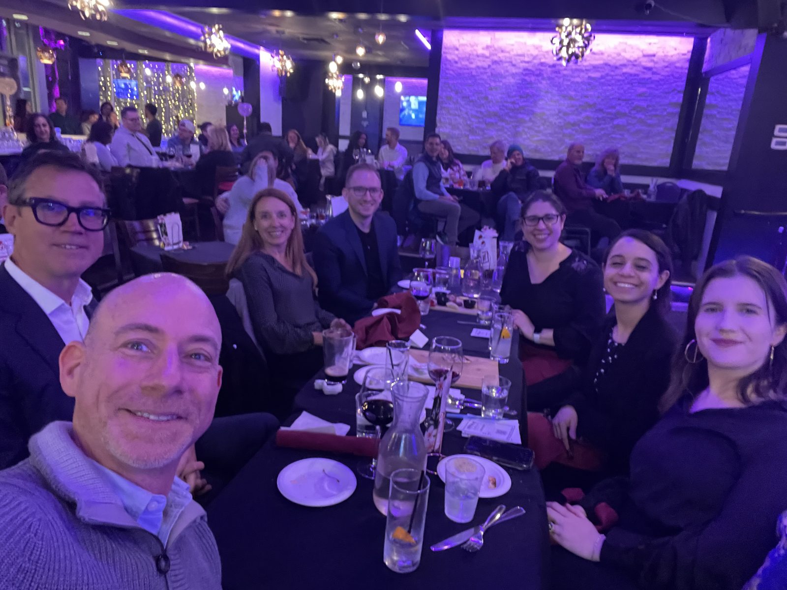 Members at a lively dinner with festive lighting