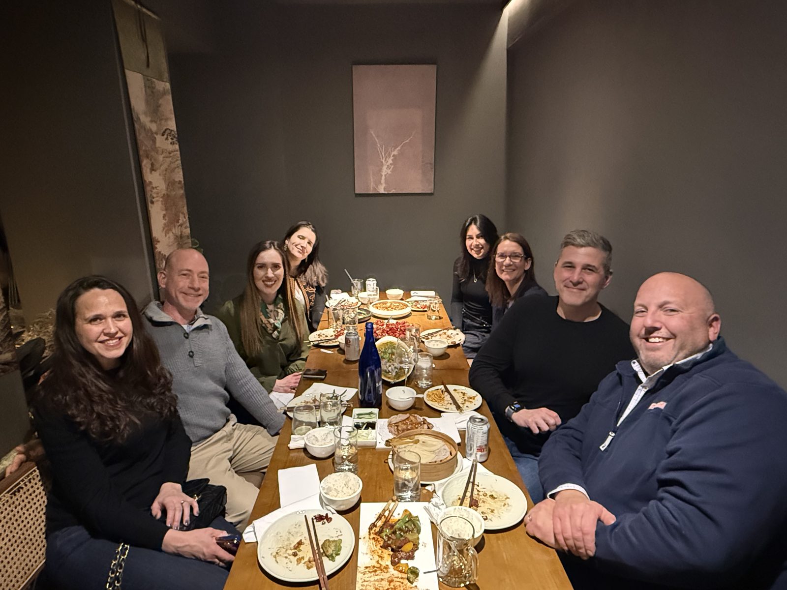 Members at a dinner around a long wooden table